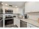 Modern kitchen featuring white cabinets, granite countertops, and stainless steel appliances at 5245 Amulet Dr # 306, New Port Richey, FL 34652