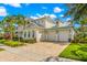Two-story home with light-colored siding, a metal roof, and a paver driveway at 709 Manns Harbor Dr, Apollo Beach, FL 33572