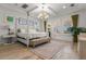 Spacious main bedroom with a large bed, chandelier, and sitting area at 709 Manns Harbor Dr, Apollo Beach, FL 33572