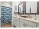 Shared bathroom with a double vanity and blue shower curtain at 709 Manns Harbor Dr, Apollo Beach, FL 33572