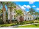 Two-story home with light-colored siding, a metal roof, and lush landscaping at 709 Manns Harbor Dr, Apollo Beach, FL 33572