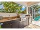 Outdoor kitchen features granite counters, stainless steel grill, and pizza oven at 709 Manns Harbor Dr, Apollo Beach, FL 33572