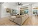 Spacious living area featuring a large sectional sofa, hardwood floors and sliding doors to the pool area at 709 Manns Harbor Dr, Apollo Beach, FL 33572