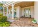 Covered front porch with a teal door, and brick flooring at 709 Manns Harbor Dr, Apollo Beach, FL 33572