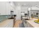 Well-equipped kitchen featuring white cabinets, a large island with sink, and a stylish backsplash at 709 Manns Harbor Dr, Apollo Beach, FL 33572