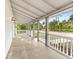 Large front porch with wooden floors and white railings at 55 W Lemon St, Tarpon Springs, FL 34689