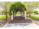 Brick pathway under a lush green vine-covered archway in a community at 21811 Lyonia Ln, Land O Lakes, FL 34637