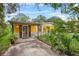 Cute yellow house with covered entry and mature landscaping at 7313 S Obrien St, Tampa, FL 33616