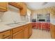 Kitchen with wood cabinets, double sink, and tile floor at 7313 S Obrien St, Tampa, FL 33616