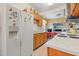 Kitchen with wood cabinets, white appliances and tile floor at 7313 S Obrien St, Tampa, FL 33616