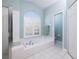 Spa-like bathroom featuring a large soaking tub, shower, and window at 3623 Doral St, Palm Harbor, FL 34685