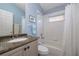 Simple bathroom with granite countertop, bathtub, and window at 3623 Doral St, Palm Harbor, FL 34685