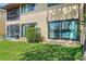 Ground level patio with grass, shrubs, and sliding glass doors at 750 N Village N Dr # 106, St Petersburg, FL 33716