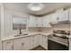 Modern kitchen with white shaker cabinets, quartz countertops, and stainless steel range at 10162 115Th Ave, Largo, FL 33773