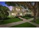 Charming home with a covered porch, balcony, and lush landscaping under a tree with string lights at 106 19Th Ave, St Pete Beach, FL 33706