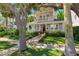 Charming two-story home with a inviting front porch, manicured lawn, and lush landscaping at 106 19Th Ave, St Pete Beach, FL 33706