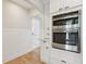 Kitchen with stainless steel built-in ovens and white cabinets with view to hallway at 106 19Th Ave, St Pete Beach, FL 33706