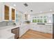 Bright and airy kitchen with white cabinetry, a farmhouse sink, and stainless steel appliances at 106 19Th Ave, St Pete Beach, FL 33706