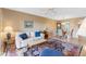 Open living room and dining area with beige sofa and patterned rug at 5775 Park N St # 411, St Petersburg, FL 33709