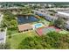 Community pool, tennis court, and clubhouse with pond view at 5775 Park N St # 411, St Petersburg, FL 33709