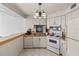 Galley kitchen with white cabinets and appliances at 1515 Pinellas Bayway S # 65, St Petersburg, FL 33715