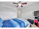 Bedroom with ceiling fan, blue bedding and built-in shelving at 116 Caladium Ct, Bradenton, FL 34212