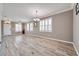 Open living room with neutral walls, wood-look floors, and white shutters at 116 Caladium Ct, Bradenton, FL 34212