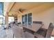 Covered patio with wicker furniture and dining table next to the pool at 116 Caladium Ct, Bradenton, FL 34212