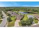 Aerial view of a house with a pool and a large backyard, near a pond at 116 Caladium Ct, Bradenton, FL 34212