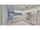 White kitchen with stainless steel appliances and view to living area at 4654 Mirabella Ct, St Pete Beach, FL 33706