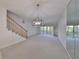 Spacious living room with mirrored wall and stairs at 4654 Mirabella Ct, St Pete Beach, FL 33706