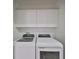 Laundry room with white cabinets and matching washer and dryer at 4654 Mirabella Ct, St Pete Beach, FL 33706