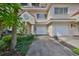 Front view of townhouse with two-car garage and landscaping at 4654 Mirabella Ct, St Pete Beach, FL 33706