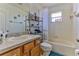 Bathroom with tub shower combo and wood vanity at 8556 Southern Charm Cir, Brooksville, FL 34613