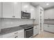 Modern kitchen features with white cabinets and granite countertops at 2505 Arch Ave, Oldsmar, FL 34677
