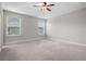 Spacious bedroom with carpeted floor, ceiling fan, and two windows with blinds at 2505 Arch Ave, Oldsmar, FL 34677