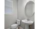 Modern powder room with pedestal sink and oval mirror at 2505 Arch Ave, Oldsmar, FL 34677