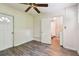 Bedroom with wood-look floors, ceiling fan, and access to laundry at 1618 Valencia St, Clearwater, FL 33756