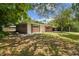 Side view of a mid-century home nestled among trees at 1618 Valencia St, Clearwater, FL 33756