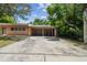Exterior view of a ranch-style home with carport and mature landscaping at 1618 Valencia St, Clearwater, FL 33756