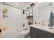Clean bathroom with white subway tile, a shower/tub combo, and gray vanity at 5690 Bayview Dr, Seminole, FL 33772