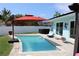 Inviting backyard oasis featuring a refreshing pool, hot tub, and patio area at 5690 Bayview Dr, Seminole, FL 33772