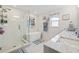 Modern bathroom with a soaking tub, walk-in shower, and marble countertops at 5690 Bayview Dr, Seminole, FL 33772