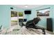 Home gym with rowing machine, massage chair, and sliding glass doors to backyard at 5690 Bayview Dr, Seminole, FL 33772