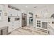 Bright kitchen featuring white shaker cabinets, stainless steel refrigerator, and wood-look flooring at 5690 Bayview Dr, Seminole, FL 33772