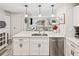 Modern kitchen with white cabinets, quartz countertops, and stainless steel appliances at 5690 Bayview Dr, Seminole, FL 33772