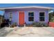 Purple house with coral door, surrounded by landscaping at 6470 64Th N Ave, Pinellas Park, FL 33781