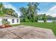 Expansive backyard with mature trees, a concrete patio, and ample space for outdoor activities at 102 Shore W Dr, Oldsmar, FL 34677