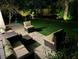 Inviting backyard at night has a patio, furniture, hammock, and landscaping at 1503 Edna Ave Nw, Largo, FL 33770