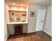 Home bar area featuring custom cabinets, counter tops, shelving, and a wine cooler at 1503 Edna Ave Nw, Largo, FL 33770